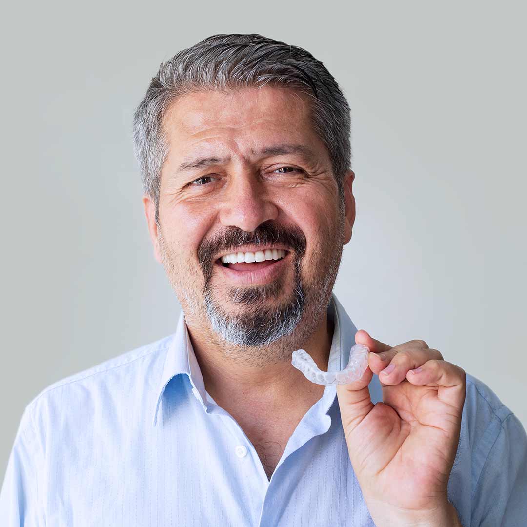 man holding a clear aligner